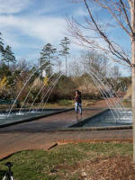 Olay runs through the Tunnel Fountain's arching sprays.