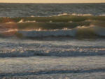 Sun's luminescence seen through early morning breakers.